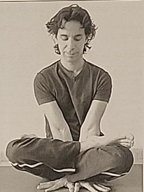 Photograph of a practitioner performing the final Samech position, lifted up on the arms with legs crossed.