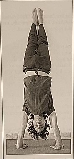 Photograph of a practitioner performing the Final Tzadi posture, a handstand with arms apart.
